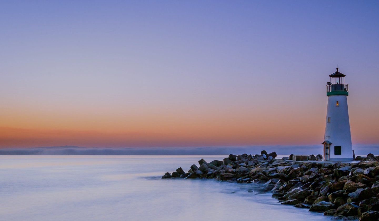 Lighthouse at dusk on a rocky shoreline